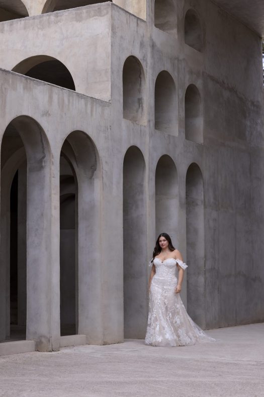 Morilee Livia 3476 is a strapless wedding dress with detachable off-the-shoulder sleeves. A sweetheart neckline on a petal shaped bodice with floral detail.