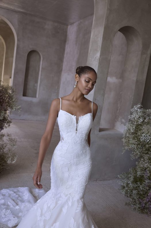 Morilee Selene 2904 is a mermaid wedding dress with floral appliqued tulle, scoop neckline, illusion side cut outs and an open back.