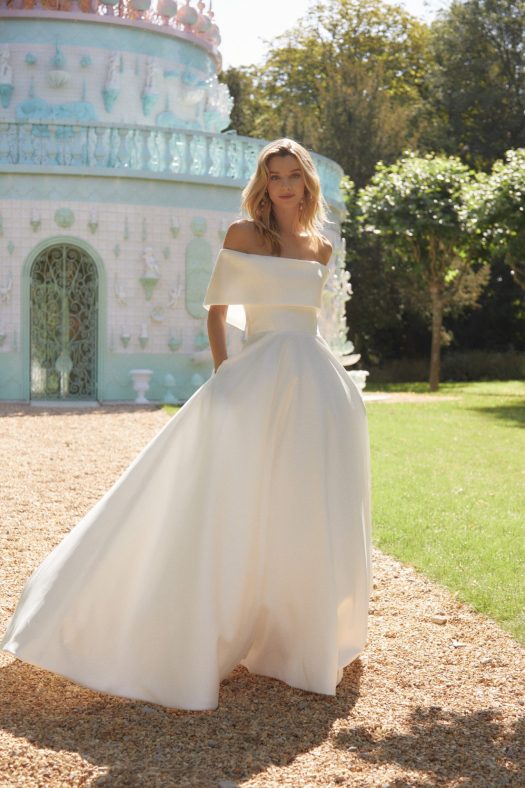 Alan Hannah wedding dress Naomi, a full skirted Mikado dress with off-the-shoulder collar. It has pockets and long train.